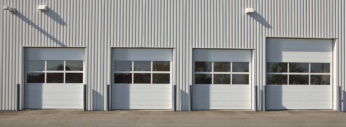 Commercial garage doors G-2023 in white on warehouse by Garaga